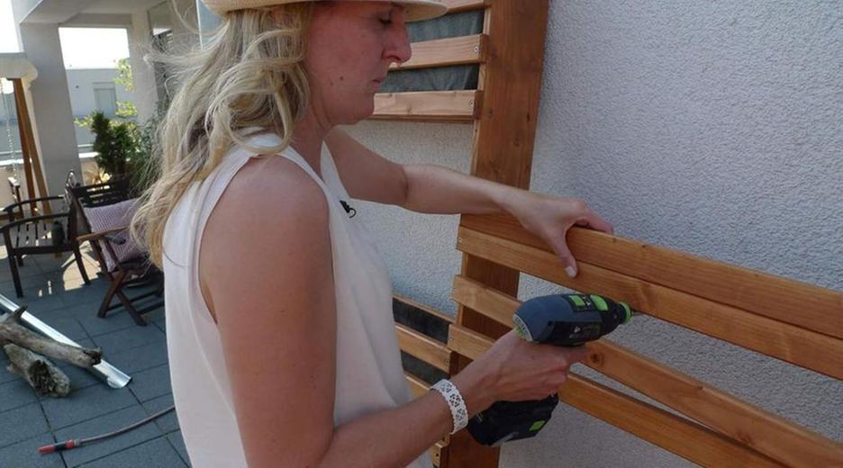 Handwerkerin verschraubt Holzlatten