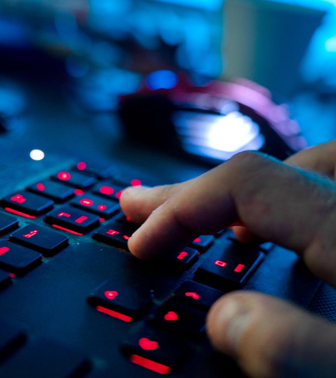 Ein Mann sitzt am Rechner und tippt auf einer Tastatur. 