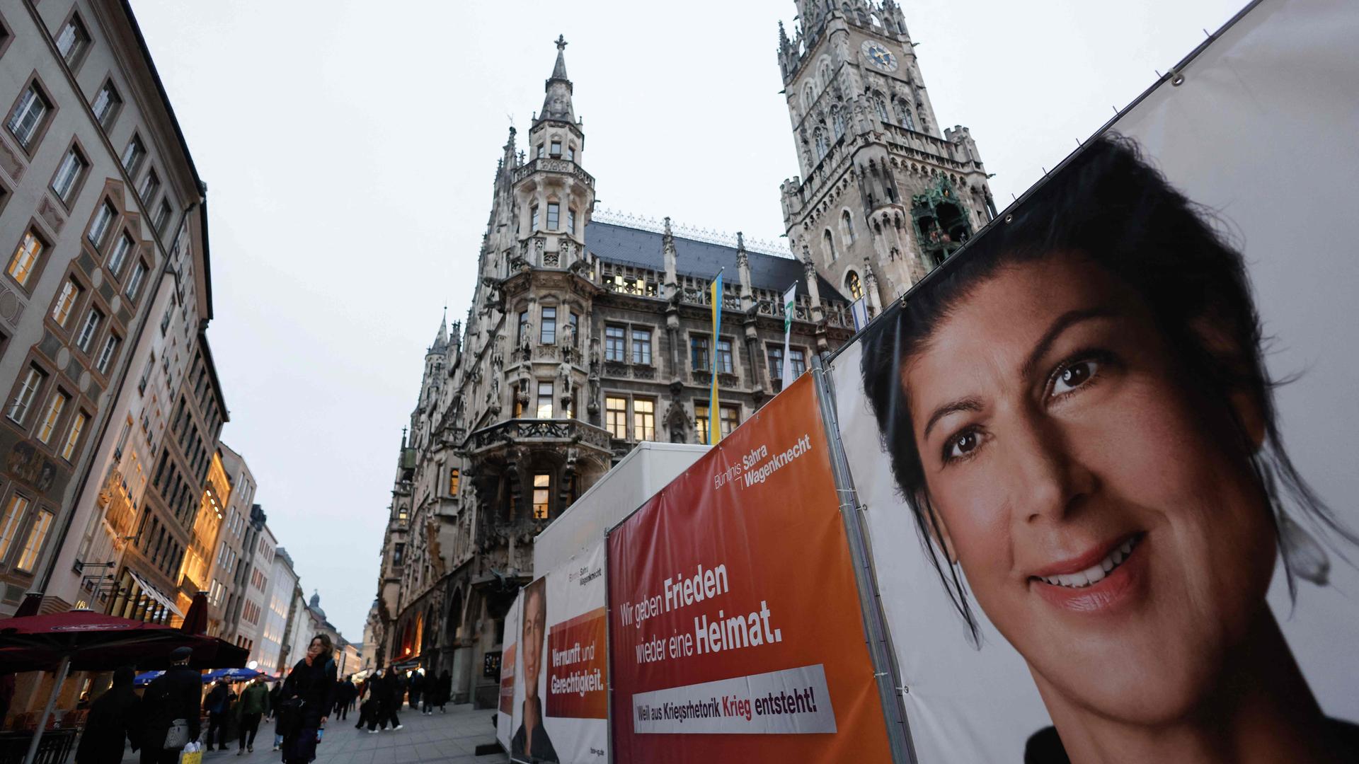 Menschen gehen an Plakaten vorbei, auf denen eine Wahlkampfveranstaltung mit der Vorsitzenden des linkspopulistischen Bündnisses Sahra Wagenknecht (BSW) angekündigt wird. Sahra Wagenknecht startet am 3. Februar 2025 auf dem zentralen Marienplatz in München den Wahlkampf der Partei.