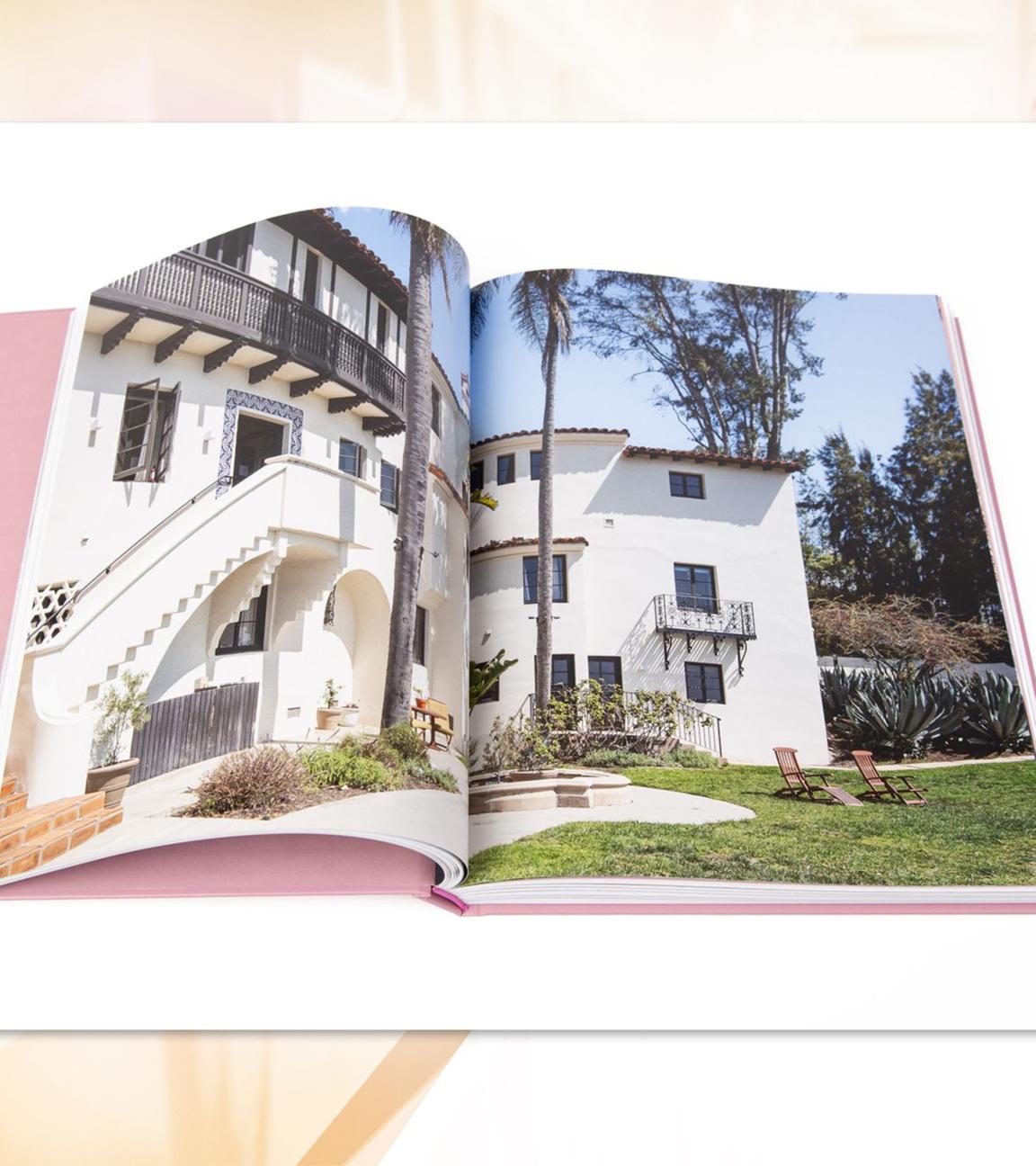 Man sieht aufgeschlagene Buchseiten mit der Fotografie einer Villa mit Garten.