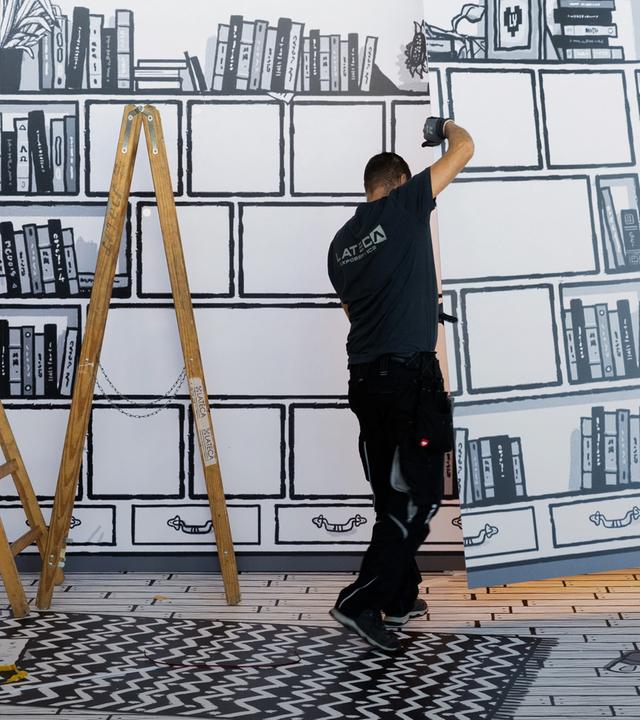 Messebauer errichten den Stand eines Buchverlages auf der Buchmesse.