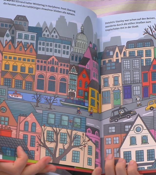 Frau hält Buch offen in die Kamera