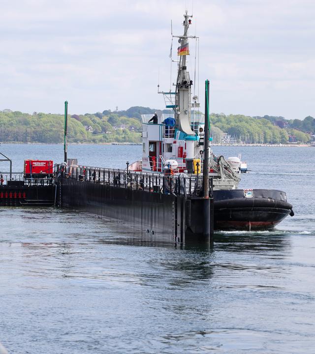 Schleswig-Holstein, Kiel: Der Schlepper "Robin Hood" und die Barge legen am Kieler Scheerhafen an.