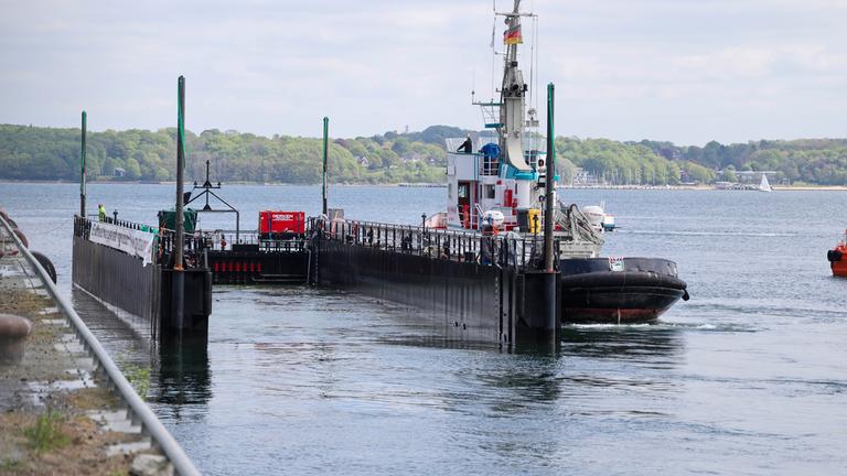 Schleswig-Holstein, Kiel: Der Schlepper "Robin Hood" und die Barge legen am Kieler Scheerhafen an.