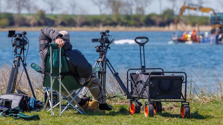 Medienvertreter beobachten die Arbeiten der Helfer direkt am festliegenden Buckelwal vor der Insel Poel.