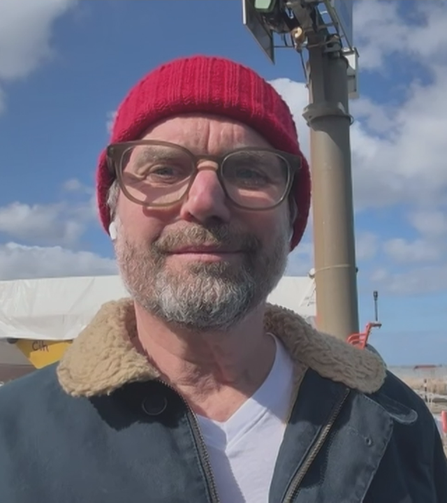 Meeresbiologe Thilo Maack per Video dazugeschaltet. Er steht im Freien unter blauem Himmel.