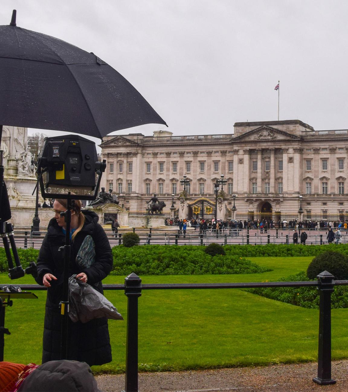 Pressevertreter versammeln sich mit Schirmen vor dem Buckingham Palace am 20.02.2026.