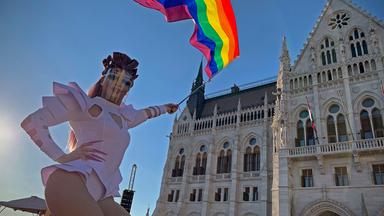 Ein Teilnehmer schwenkt am 14. Juni 2021 während einer Demonstration für LGBT-Rechte vor dem ungarischen Parlamentsgebäude in Budapest eine Regenbogenfahne.