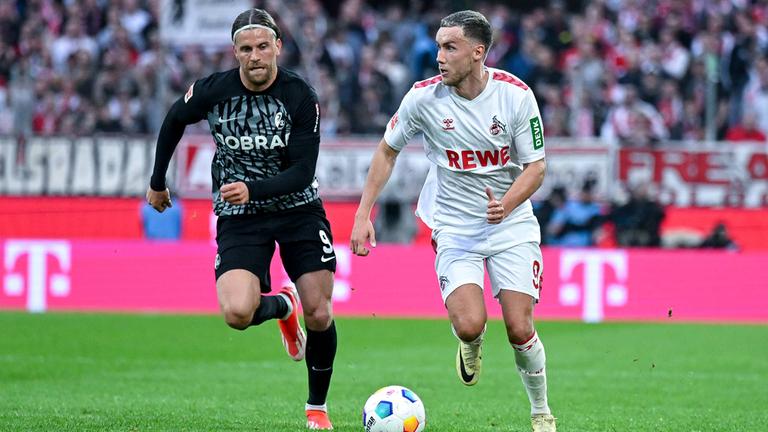 Lucas Höler (SC Freiburg) und Luca Waldschmidt r. (1. FC Köln) im Laufduell.