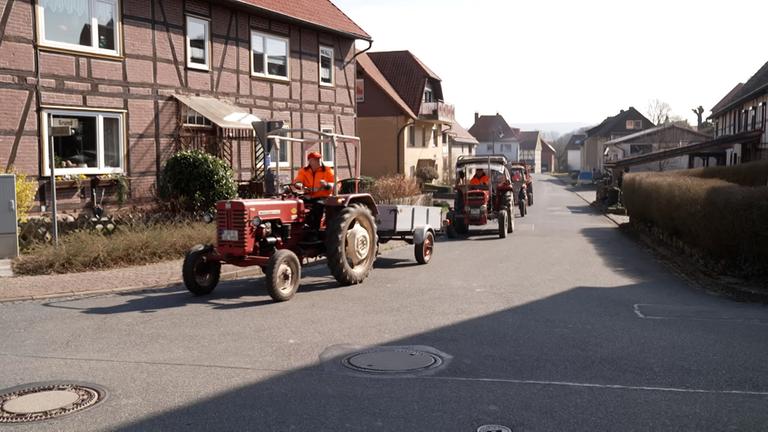 Ehrenamtliche Senioren fahren mit Traktoren durch den Ort Bühren