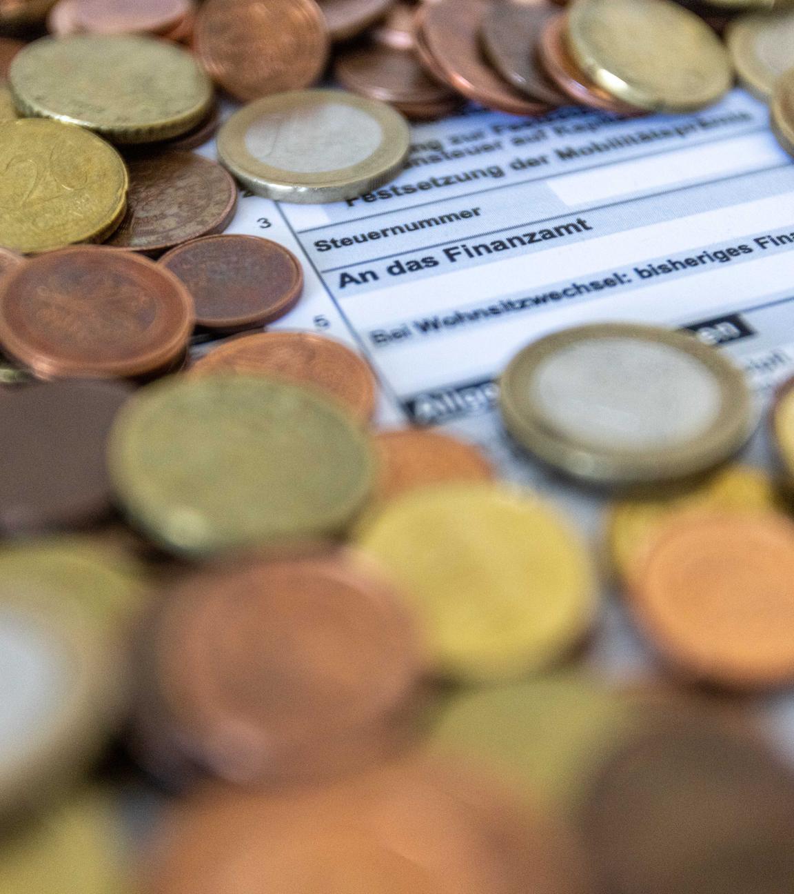  Ein Formular zur Steuererklärung ist von Euro-Münzen bedeckt.
