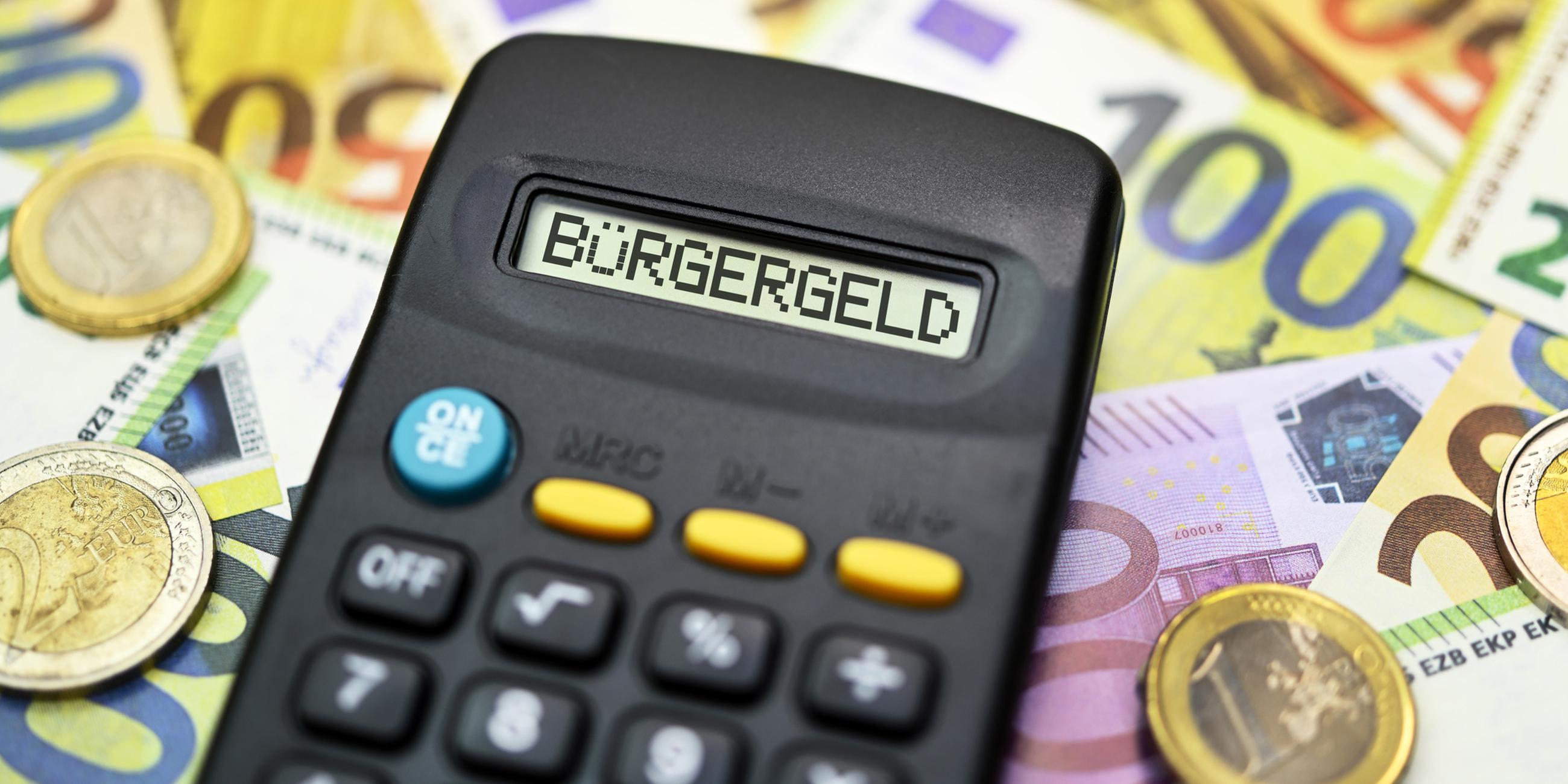 Taschenrechner mit Schriftzug Bürgergeld auf Geldscheinen 