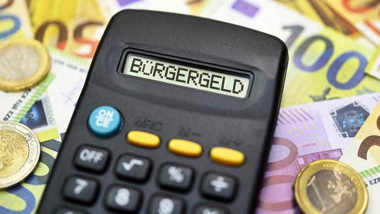 Taschenrechner mit Schriftzug Bürgergeld auf Geldscheinen 