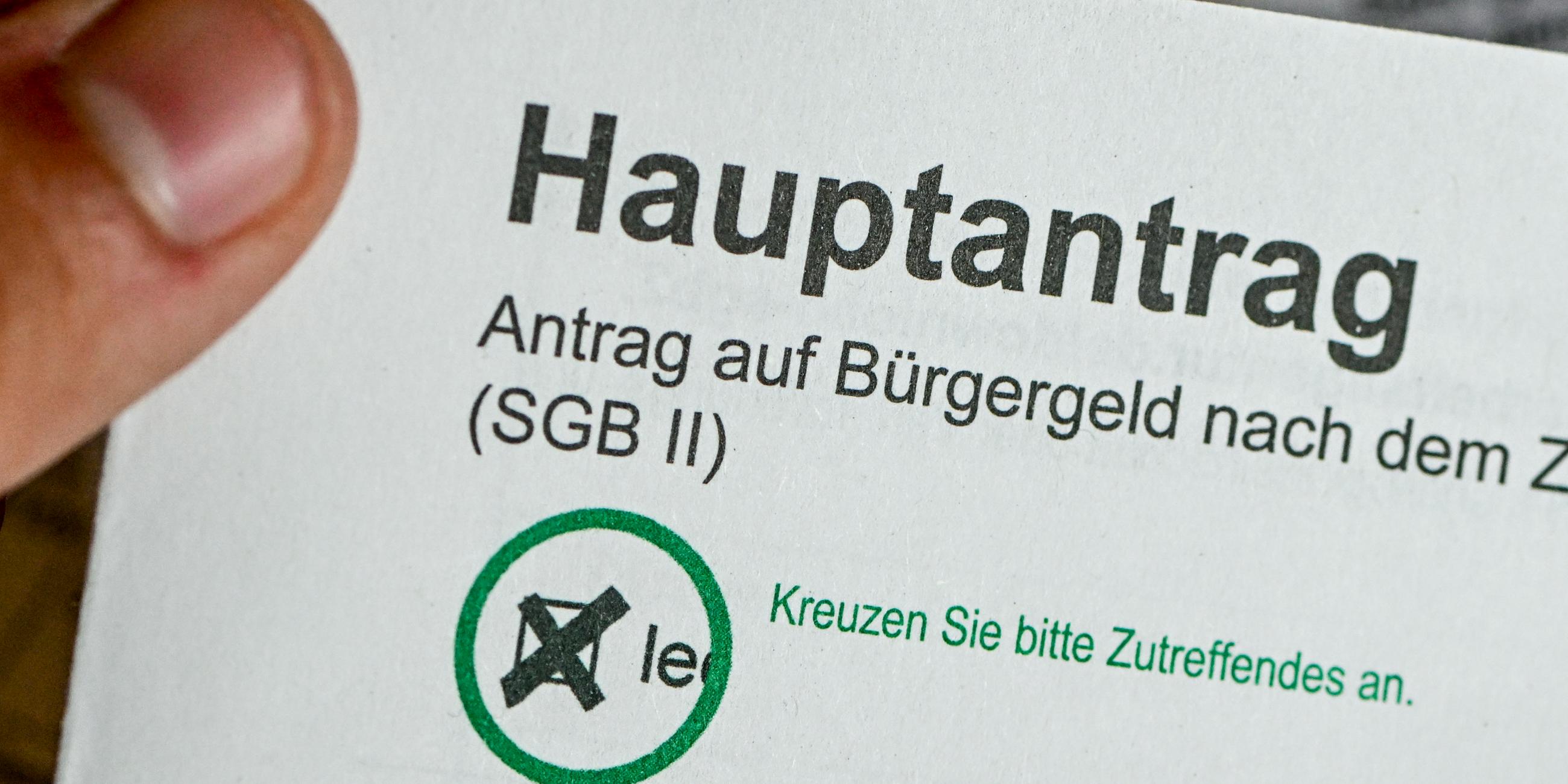 Mann hält einen Antrag auf Bürgergeld in der Hand.