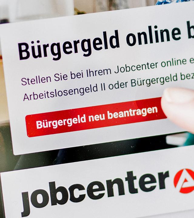 Berlin: Eine Frau tippt auf einem Tablet auf einen Link zum Beantragen des Bürgergeldes im Kundenbereich im Jobcenter Berlin Mitte.