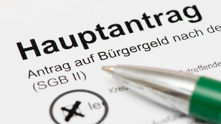 Ein Kugelschreiber liegt auf dem Formular Hauptantrag auf Bürgergeld.