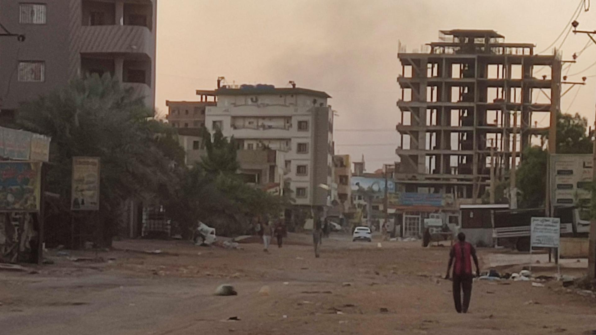 In der fast menschenleeren, zerstörten Hauptstadt Khartum, im Süden des Sudans, läuft ein Mann eine staubige Straße entlang.