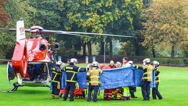 Nordrhein-Westfalen, Herdecke: Einsatzkräfte stehen neben einem Rettungshubschrauber.
