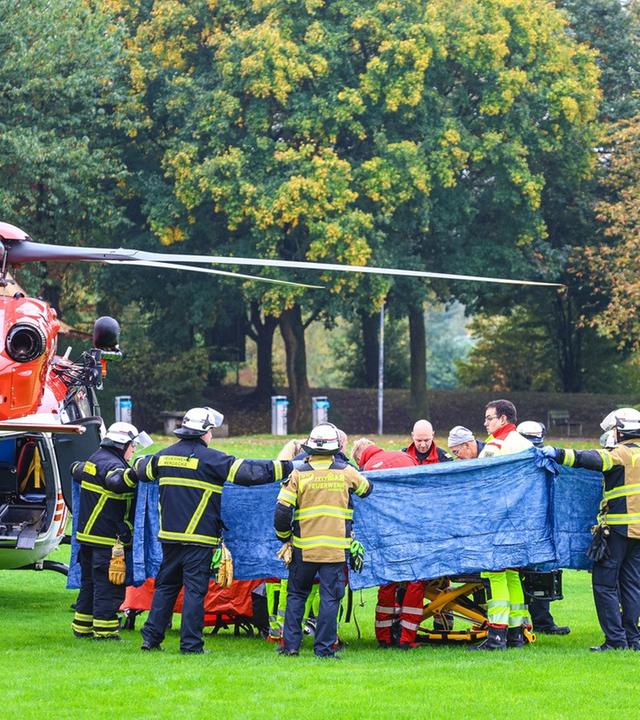 Nordrhein-Westfalen, Herdecke: Einsatzkräfte stehen neben einem Rettungshubschrauber.