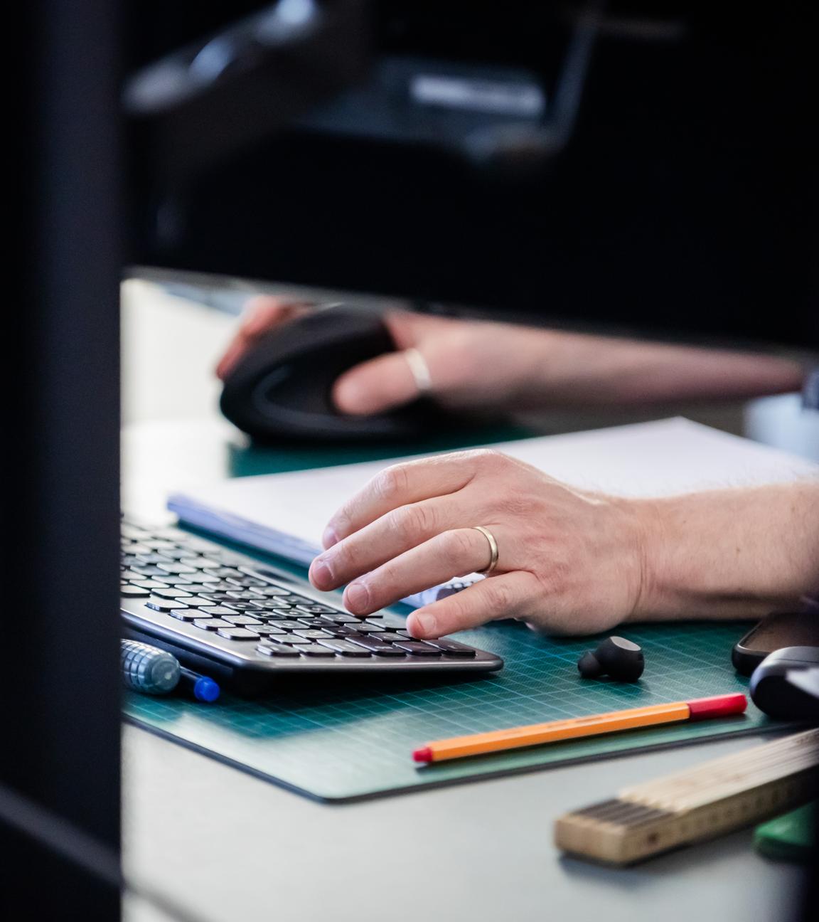 Eine Person arbeitet in einer Fabrik an einem Computer.