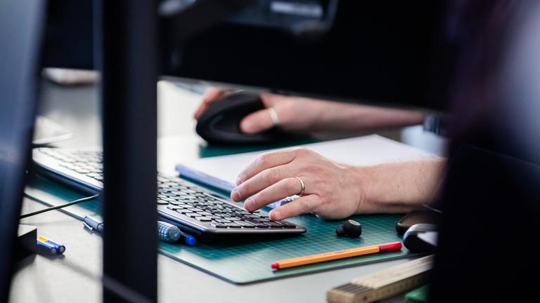 Eine Person arbeitet in einer Fabrik an einem Computer.
