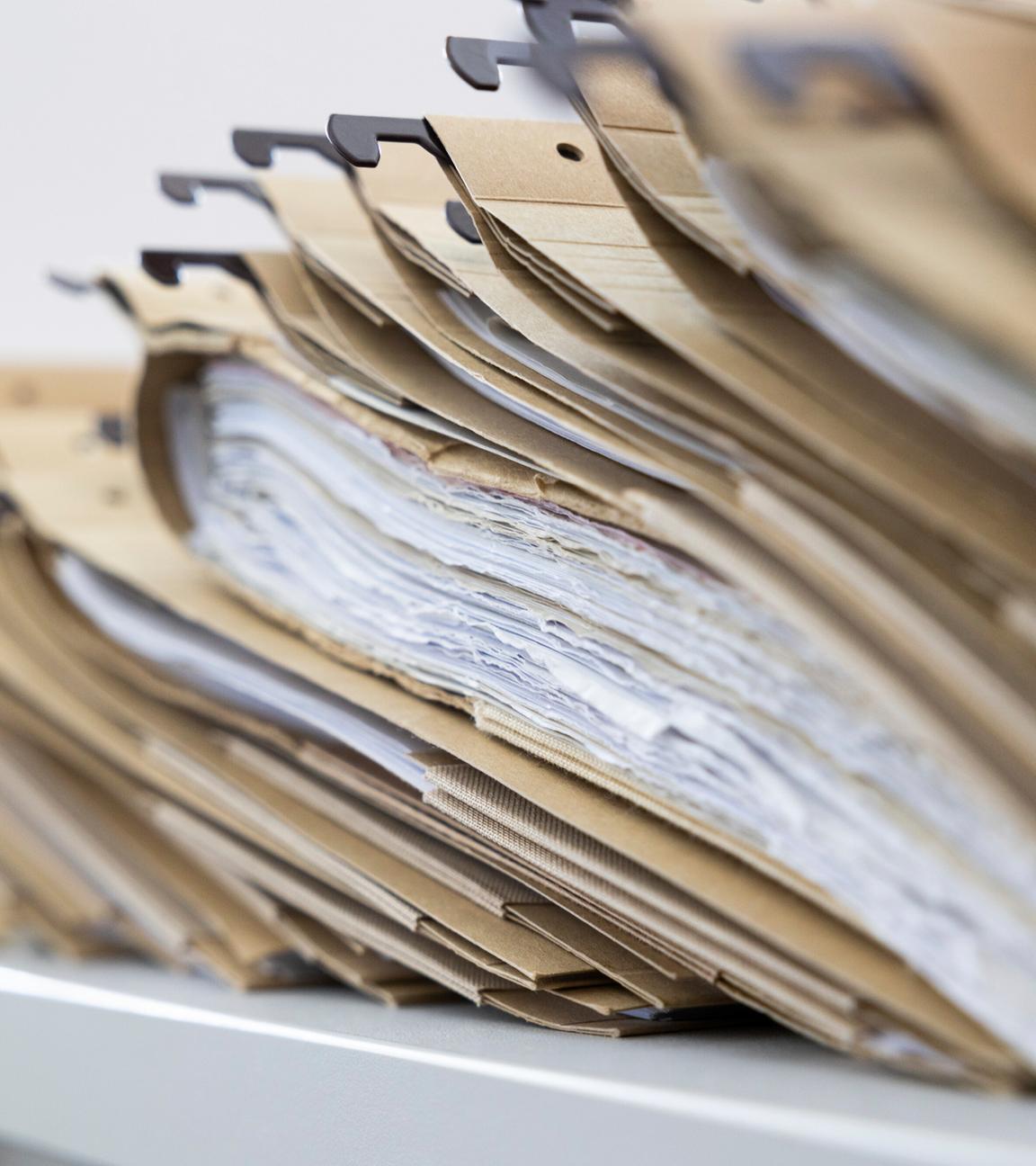 Symbolbild: Zahlreiche Akten sind auf einem Schreibtisch ausgelegt. 