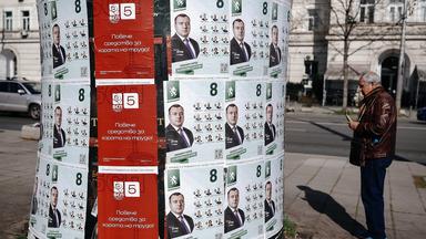 A man observes campaign posters of both Independent Bulgaria party and Bulgarian Socialist Party (BSP) in Sofia, Bulgaria, 17 April 2026.