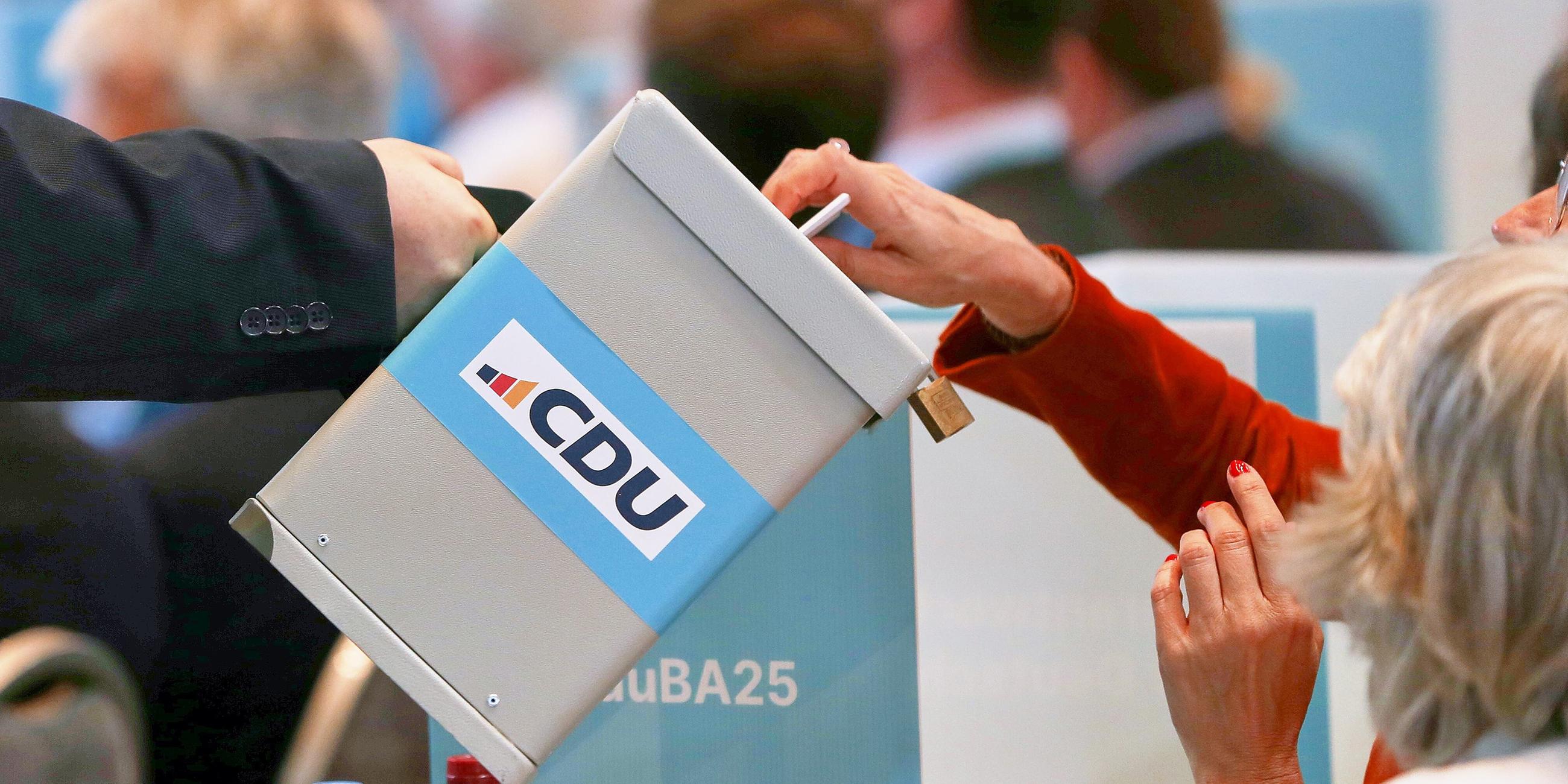 CDU-Bundesausschuss: Delegierte werfen eine Stimmkarte in eine Wahlurne
