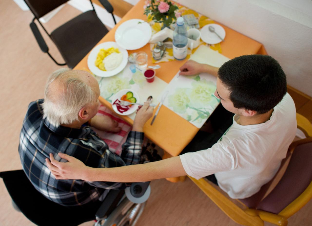Ein 19-Jähriger betreut einen 83-jährigen Mann und isst gemeinsam mit ihm.