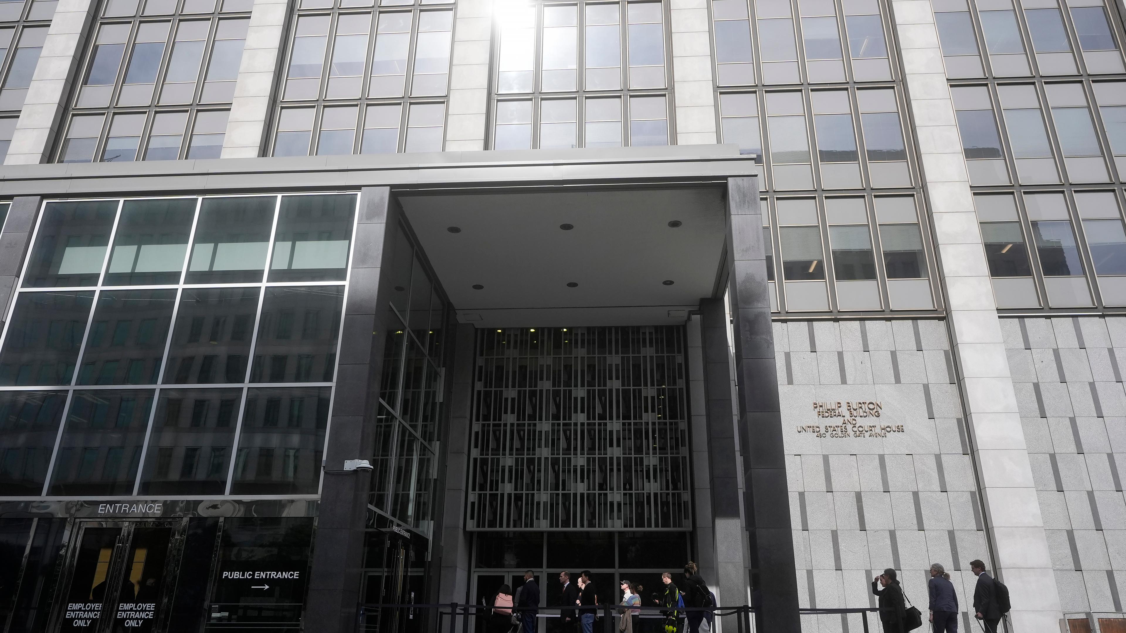 Menschen warten darauf, ein Bundesgericht zu betreten, in dem Gewerkschaften bei einer Anhörung in San Francisco einen Bundesrichter um eine einstweilige Verfügung bitten, um die Massenentlassungen von Bundesangestellten auf Bewährung durch die Regierung von Präsident Donald Trump zu verhindern
