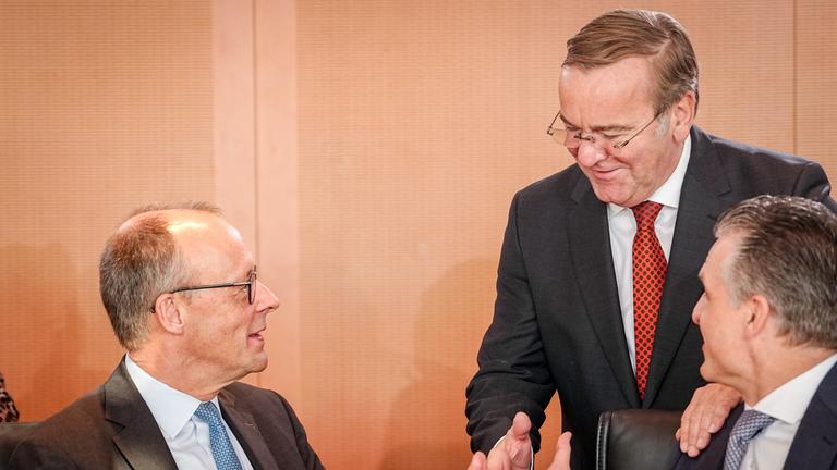 Bundeskanzler Merz, Bundesminister der Verteidigung Pistorius und chef des Bundeskanzleramts und Bundesminister Thorsten Frei nehmen an einer Sitzung des Bundeskabinetts teil. Sie unterhalten sich.