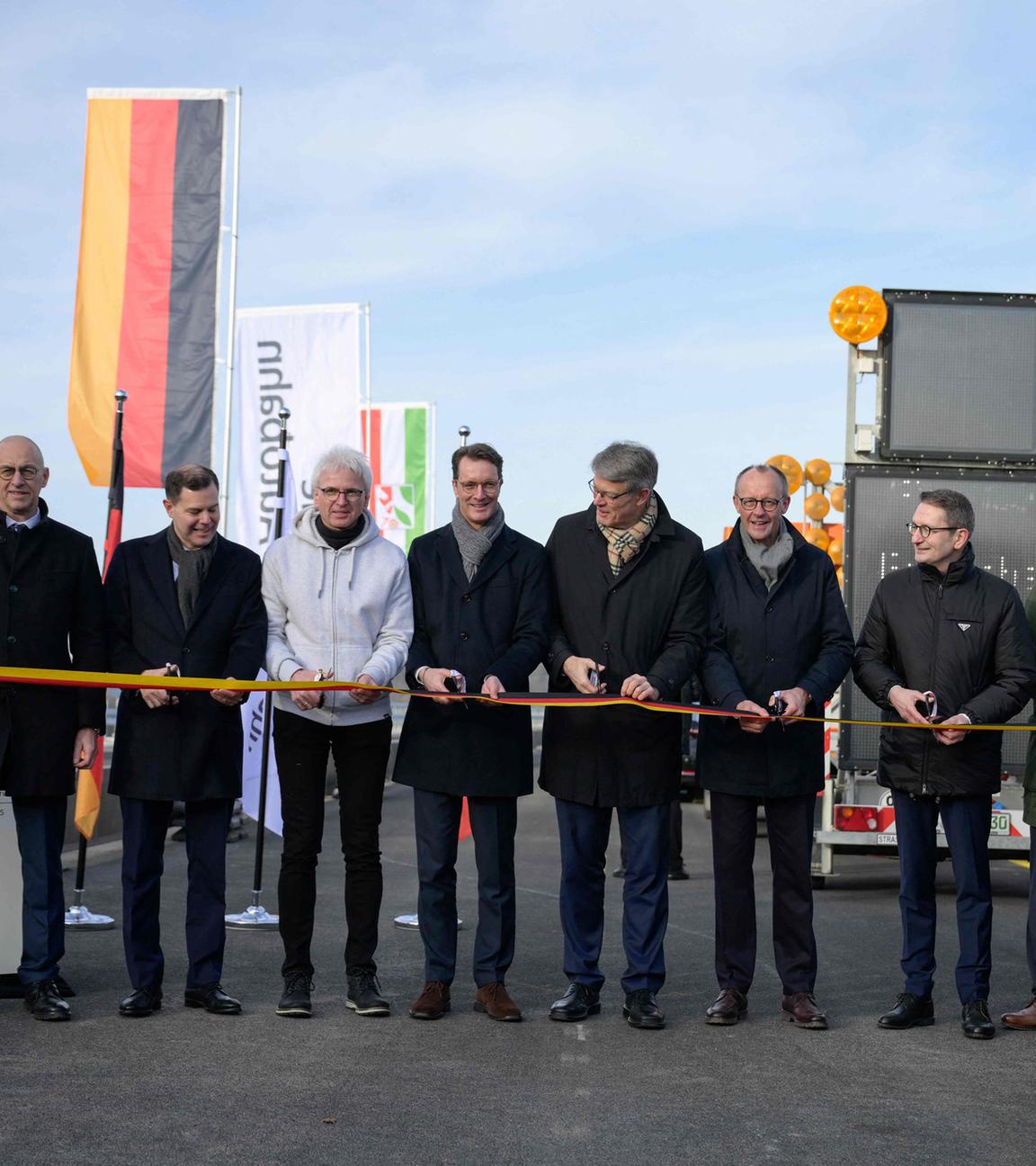 NRW-Ministerpräsident Hendrik Wüst (4. v. l.), Bundesverkehrsminister Patrick Schnieder (5. v. l.) und Kanzler Friedrich Merz (5. v. r.) durchschneiden das Band bei der Eröffnung der Rahmedetalbrücke bei Lüdenscheid.