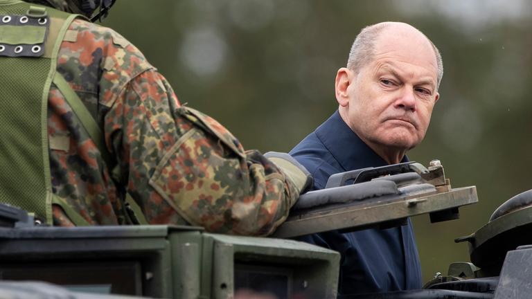 Litauen, Vilnius: Bundeskanzler Olaf Scholz (SPD) fährt auf einem gepanzerten Militärfahrzeug während der litauisch-deutschen Militärübung "Grand Quadriga" auf einem Truppenübungsplatz in Pabrade.