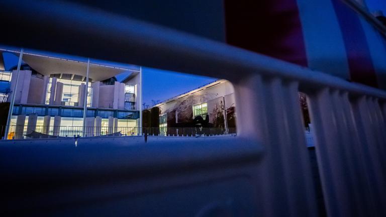 Das Bundeskanzleramt ist am Morgen durch einen Bauzaun hindurch zu sehen.