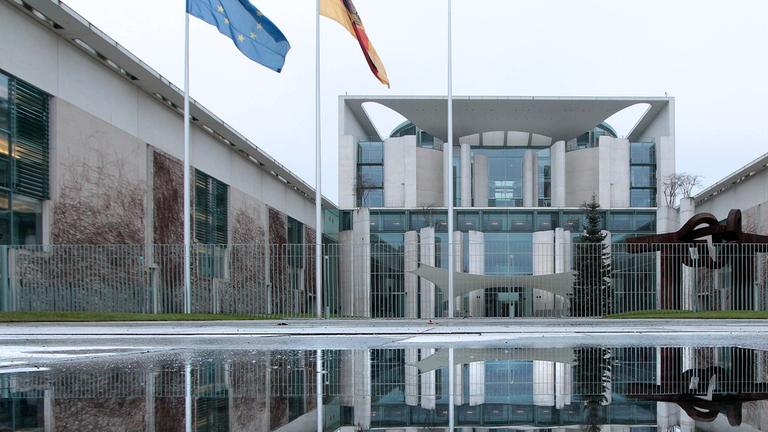 Archiv: Bundeskanzleramt spiegelt sich in einer Wasserpfütze an einem Wintertag in Berlin