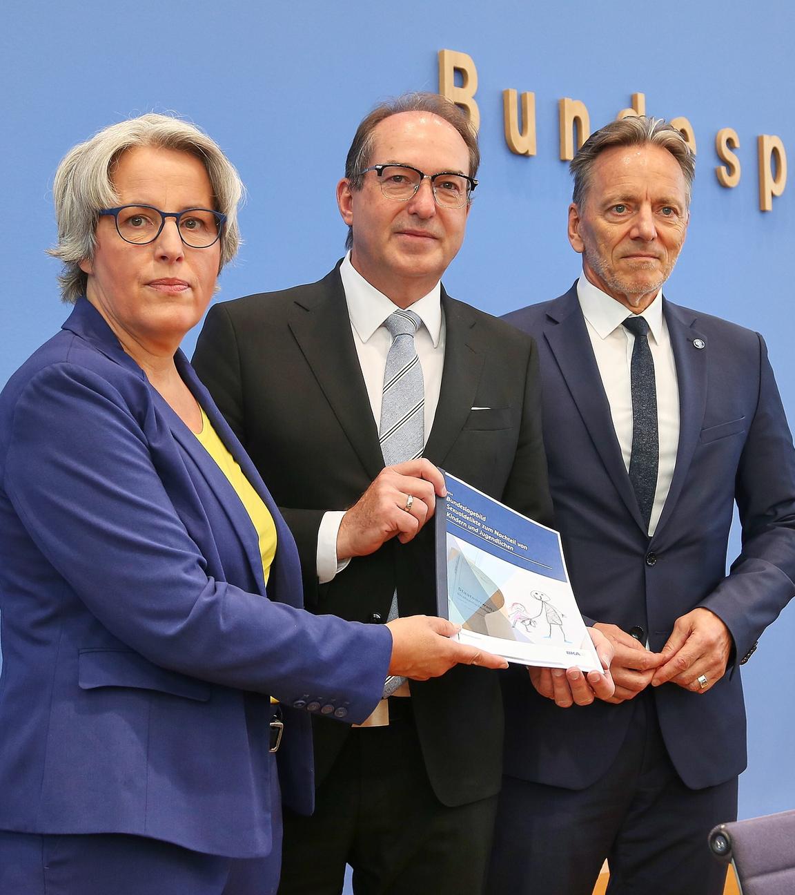 Kerstin Claus, Unabhaengige Bundesbeauftragte gegen sexuellen Missbrauch von Kindern und Jugendlichen (UBSKM), Bundesminister des Innern Alexander Dobrindt (CSU) und BKA-Praesident Holger Muench halten den Bericht des Bundeslagebilds in der Hand.