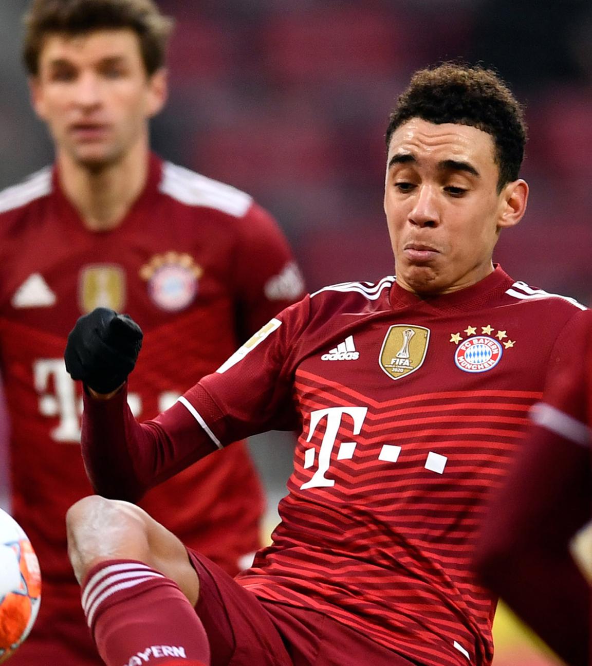 15.01.2022,  Nordrhein-Westfalen, Köln, 1. FC Köln gegen FC Bayern München, im RheinEnergieStadion, Kölns Luca Kilian (l) und Münchens Jamal Musiala kämpfen um den Ball. Dahinter sieht Münchens Thomas Müller zu.