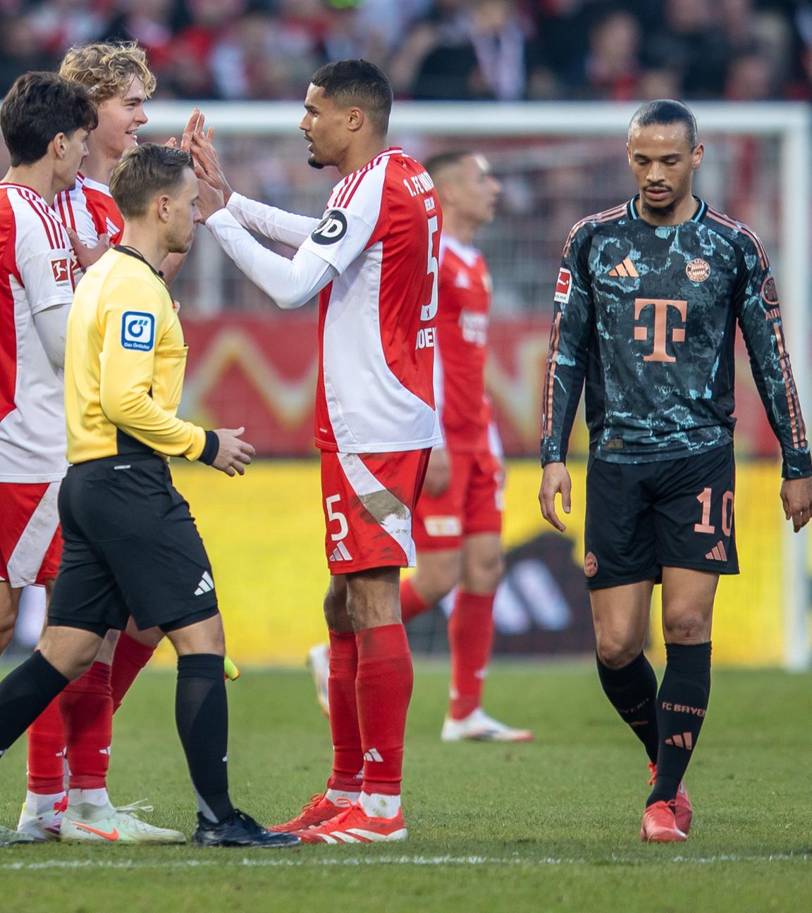 Leroy Sane und Joshua Kimmich von Bayern München reagieren auf das Ergebnis am Ende der Spielzeit, während Berlins Diogo Leite, Tom Rothe und Danilho Doekhi jubeln.