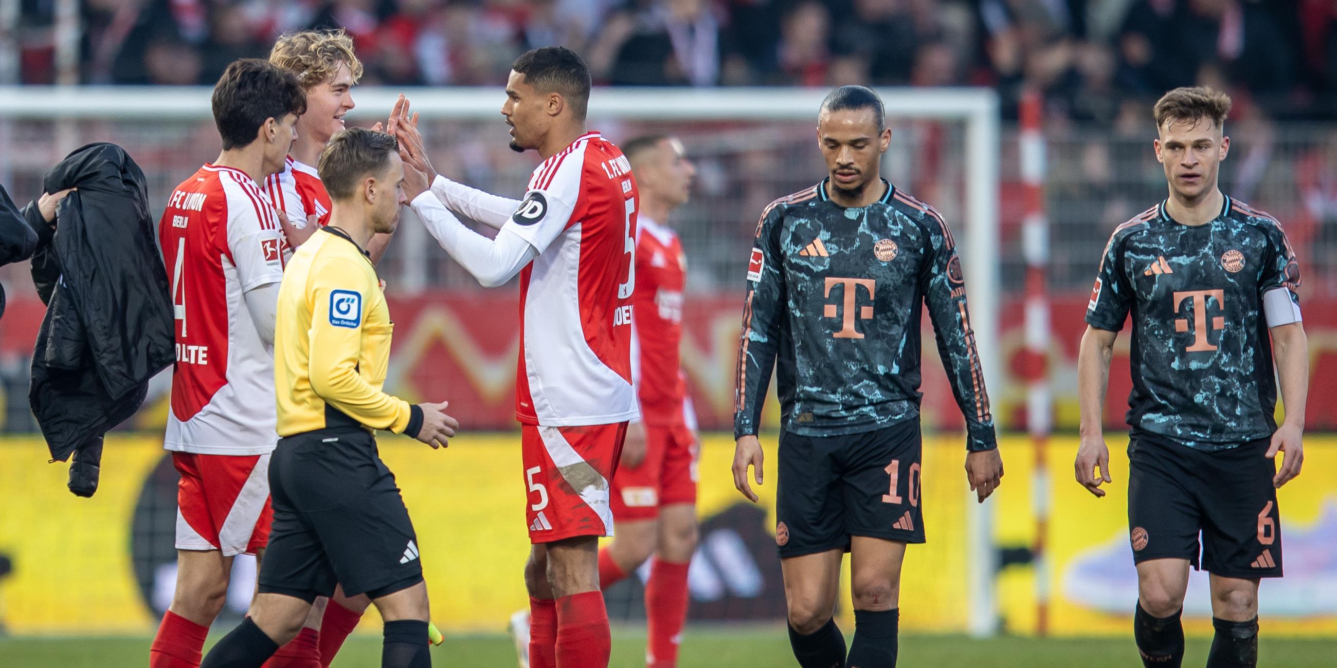 Leroy Sane und Joshua Kimmich von Bayern München reagieren auf das Ergebnis am Ende der Spielzeit, während Berlins Diogo Leite, Tom Rothe und Danilho Doekhi jubeln.