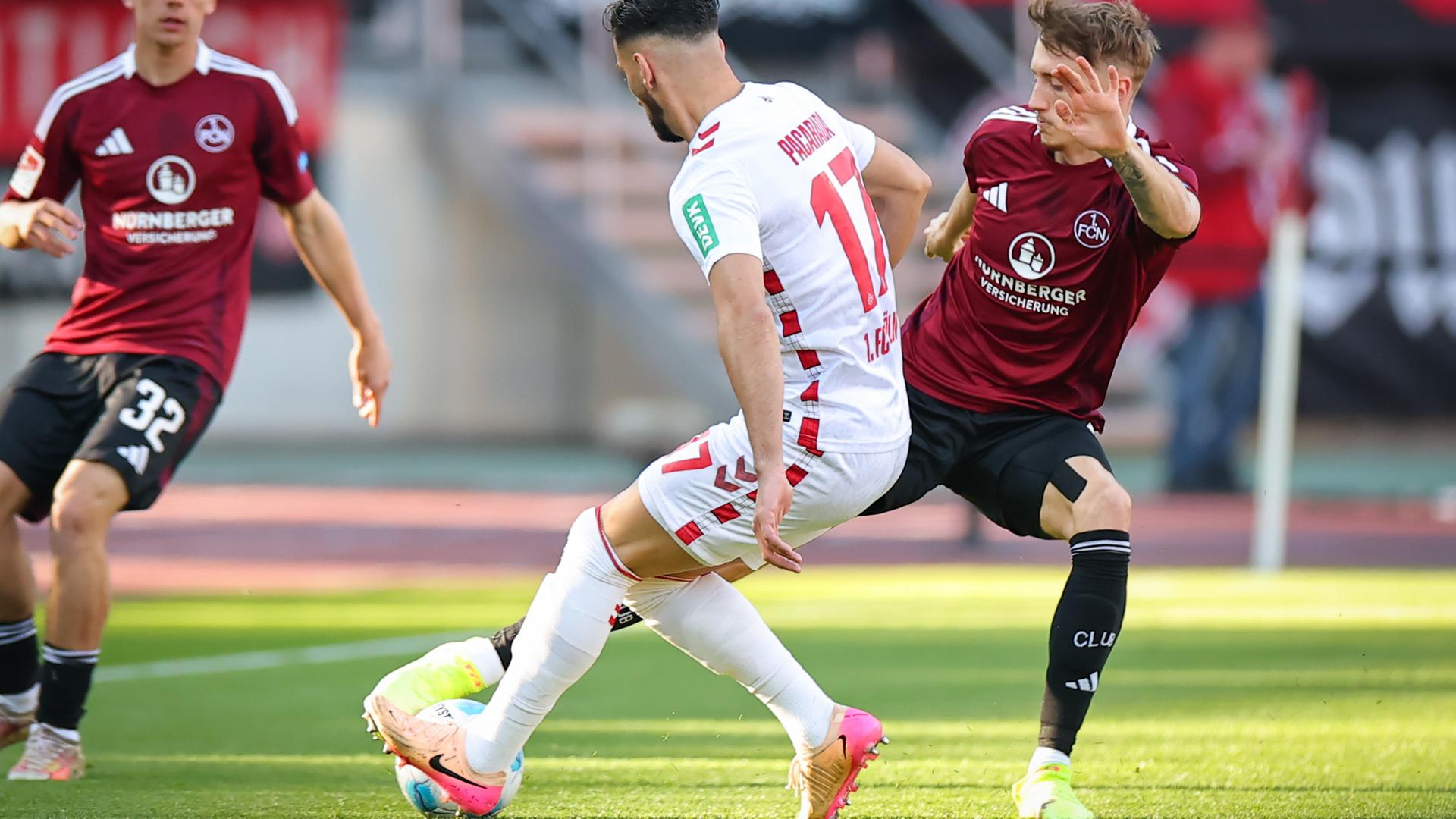 2. Bundesliga Nürnberg: Nürnberger Tim Drexler (r) kämpft mit dem Kölner Leart Paqarada (M) um den Ball am 09.05.2025