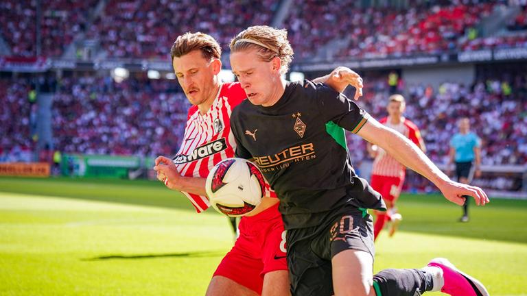 David Herold (Borussia Monchengladbach, 20) und Maximilian Eggestein (SC Freiburg, 8) im Zweikampf am 12.09.2026 in Freiburg. 