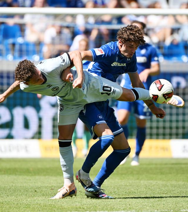 Moritz Broschinski (Karlsruher SC) und Jannik Rochelt (Arminia Bielefeld) kämpfen. 