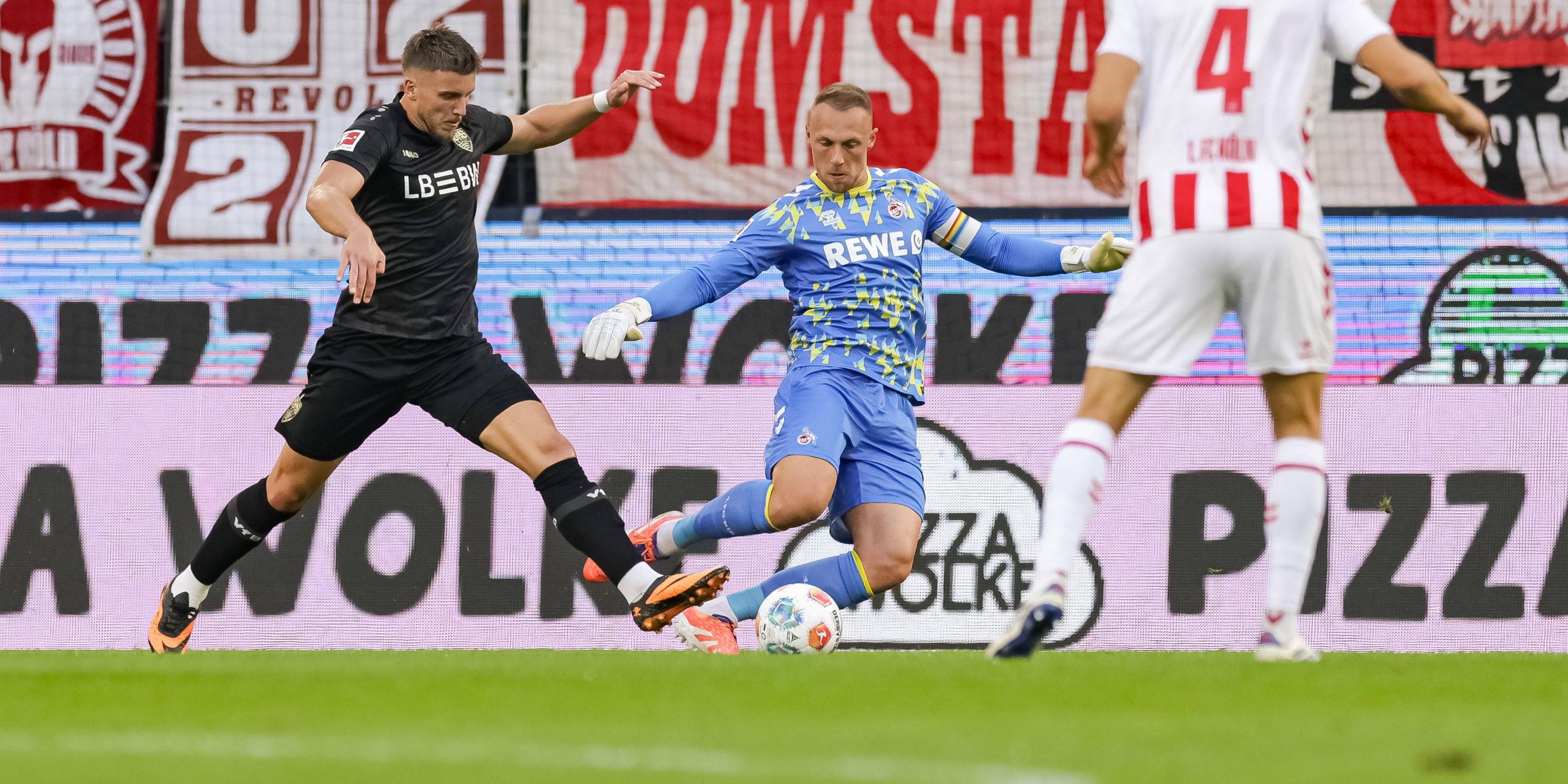 Kölns Torwart Marvin Schwäbe foult Stuttgarts Ermedin Demirovic.