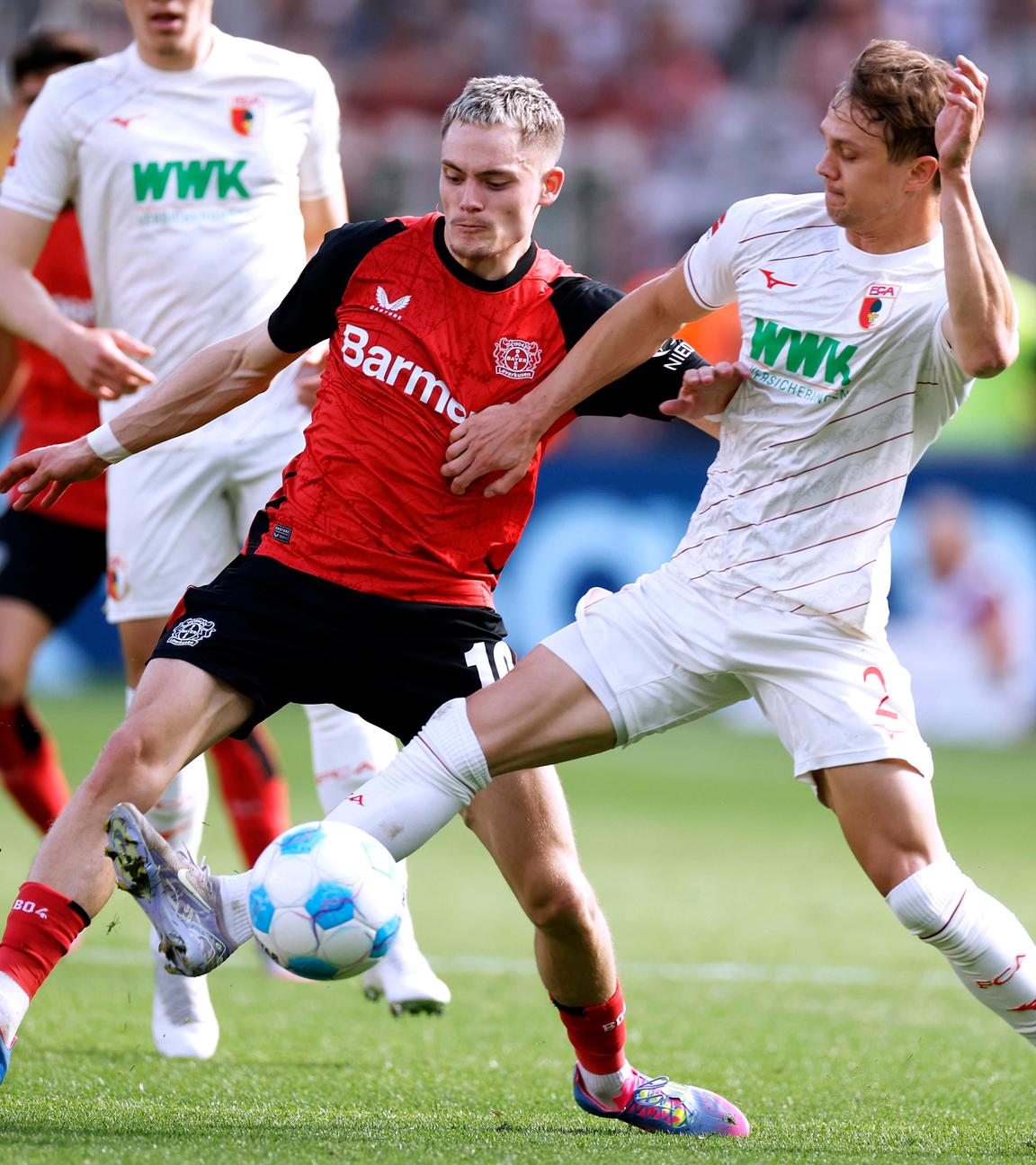 Leverkusens Florian Wirtz und Augsburgs Robert Gummy kämpfen um den Ball.