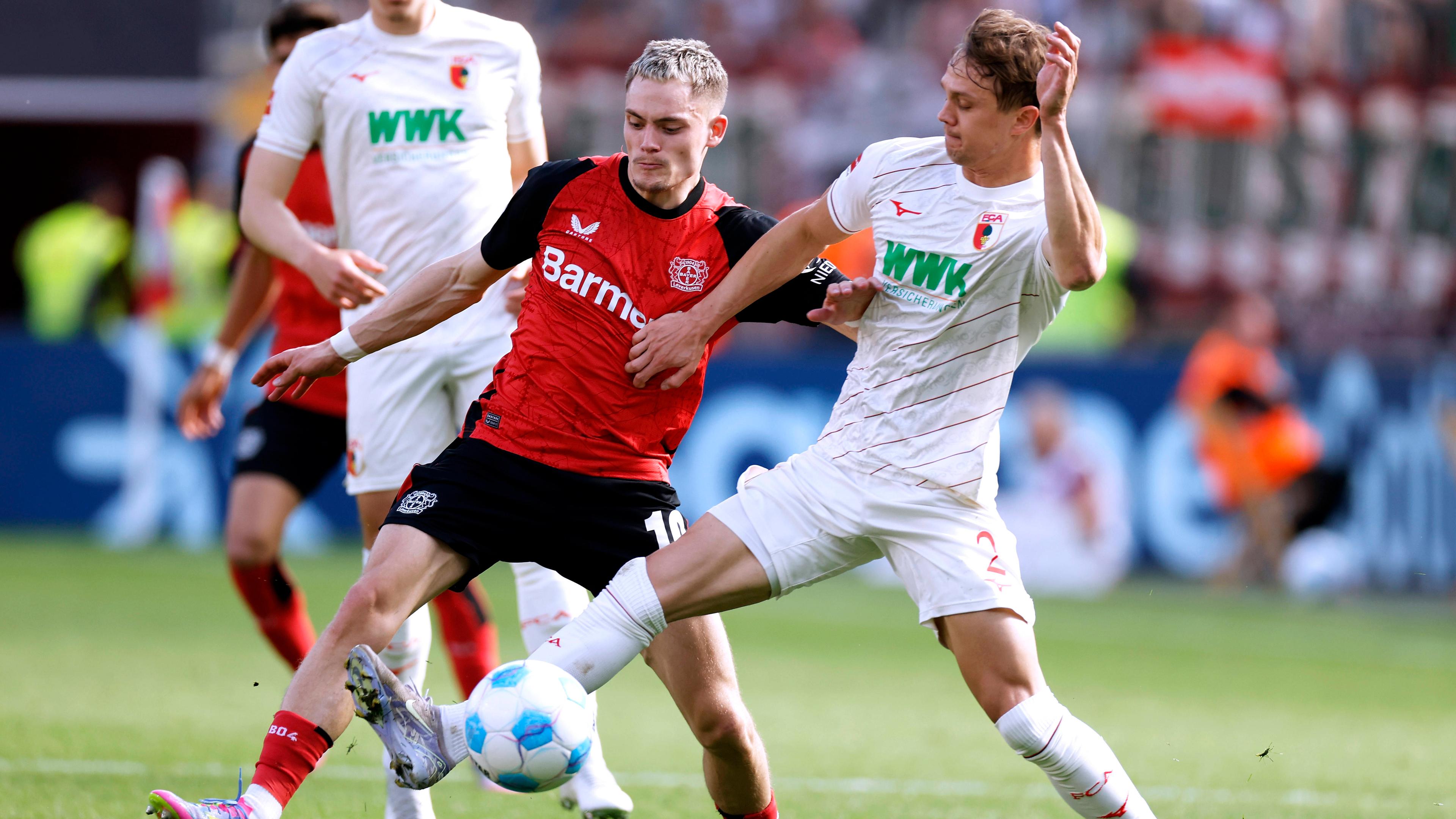 Leverkusens Florian Wirtz und Augsburgs Robert Gummy kämpfen um den Ball.