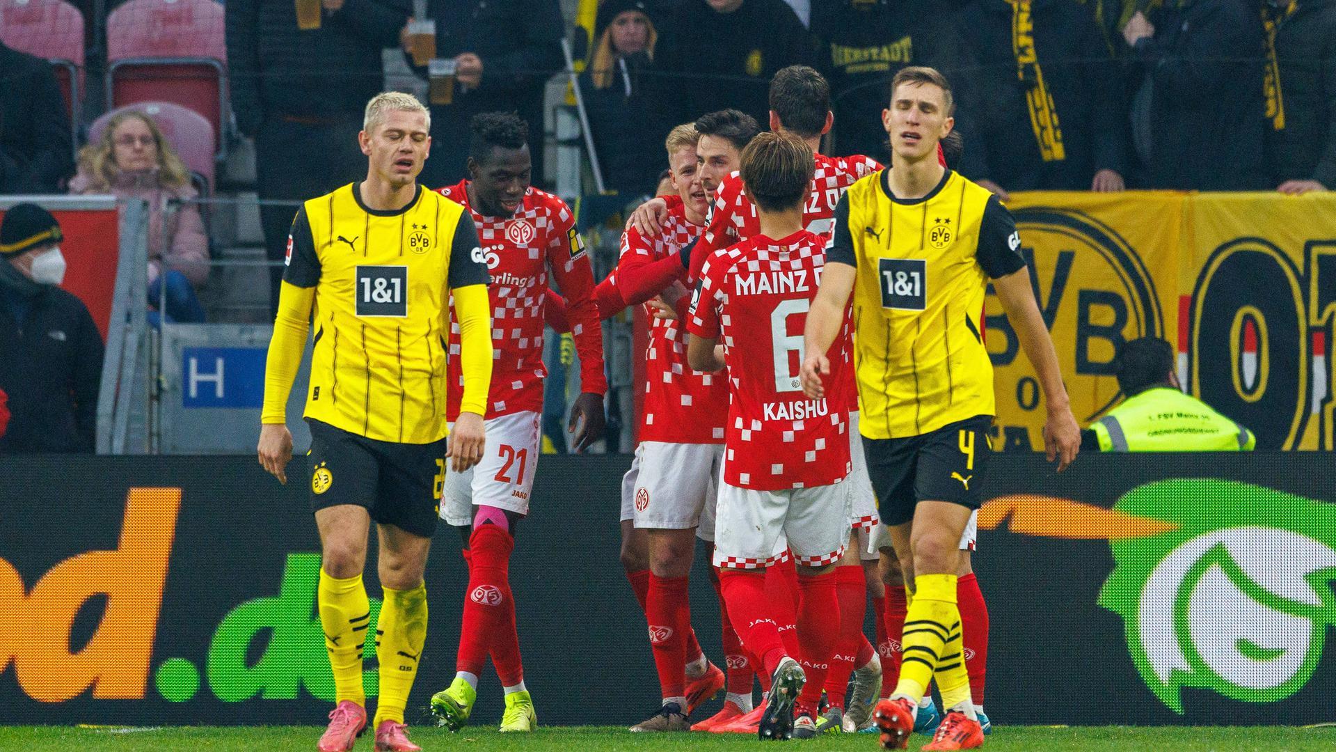 Die Mainzer jubeln im Hintergrund und die Spieler des Borussia Dortmunds sind enttäuscht.