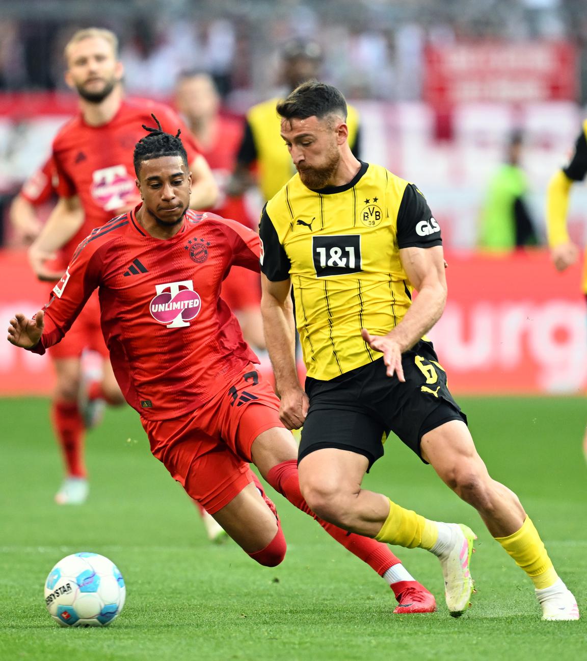 Münchens Michael Olise und Dortmunds Salih Özcan kämpfen um den Ball.
