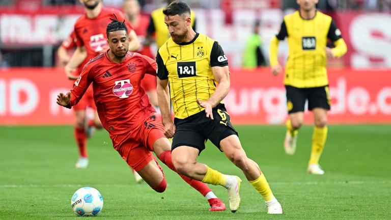 Münchens Michael Olise und Dortmunds Salih Özcan kämpfen um den Ball.