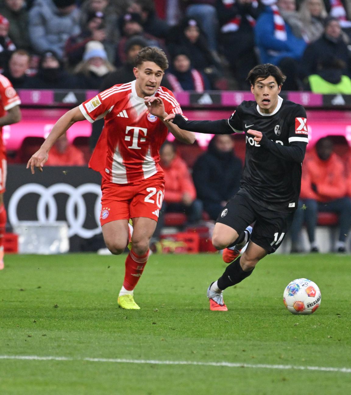 Bayern Münchens Tom Bischof  im Zweikampf gegen Freiburgs Yuito Suzuki.