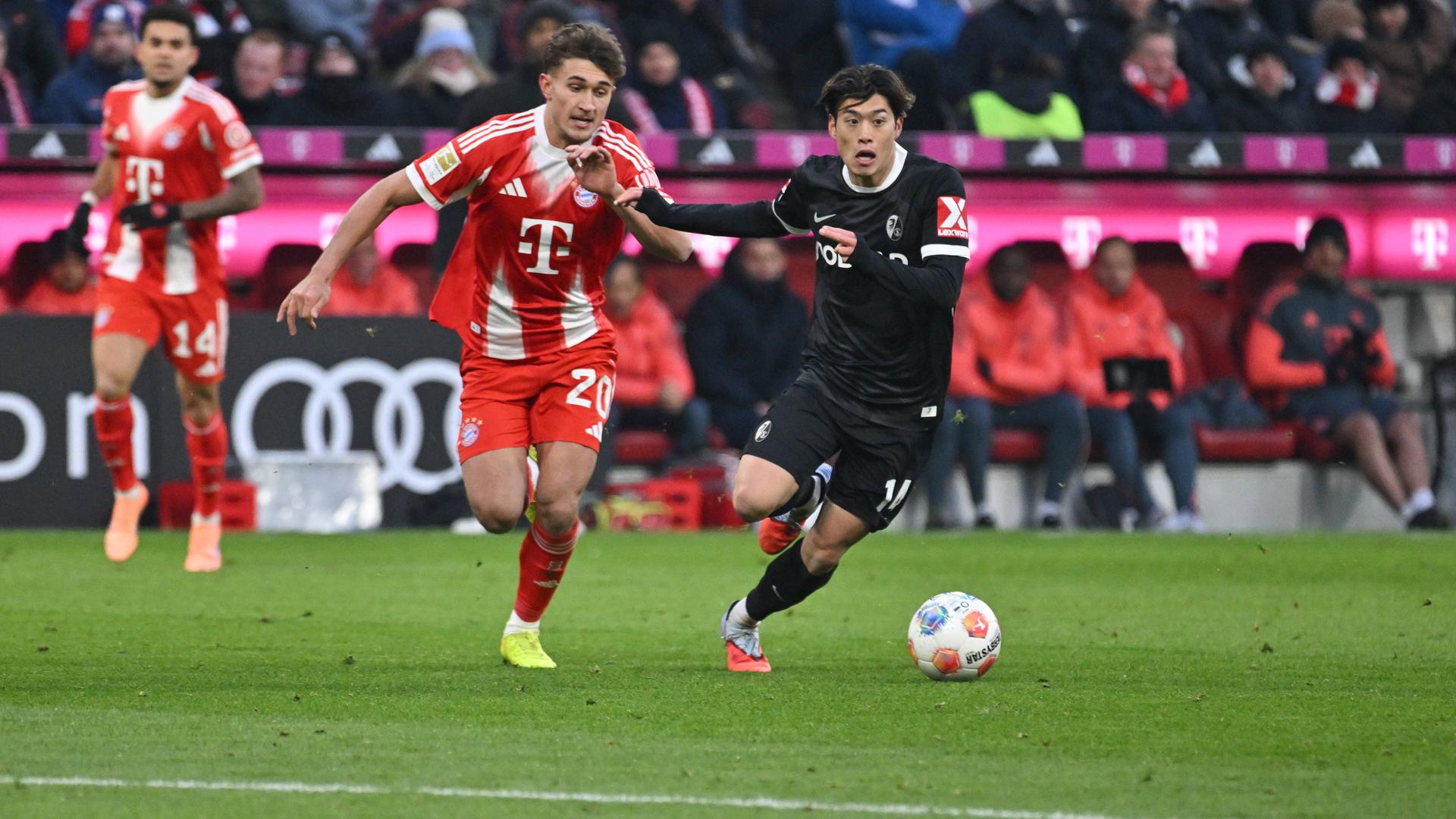 Bayern Münchens Tom Bischof  im Zweikampf gegen Freiburgs Yuito Suzuki.